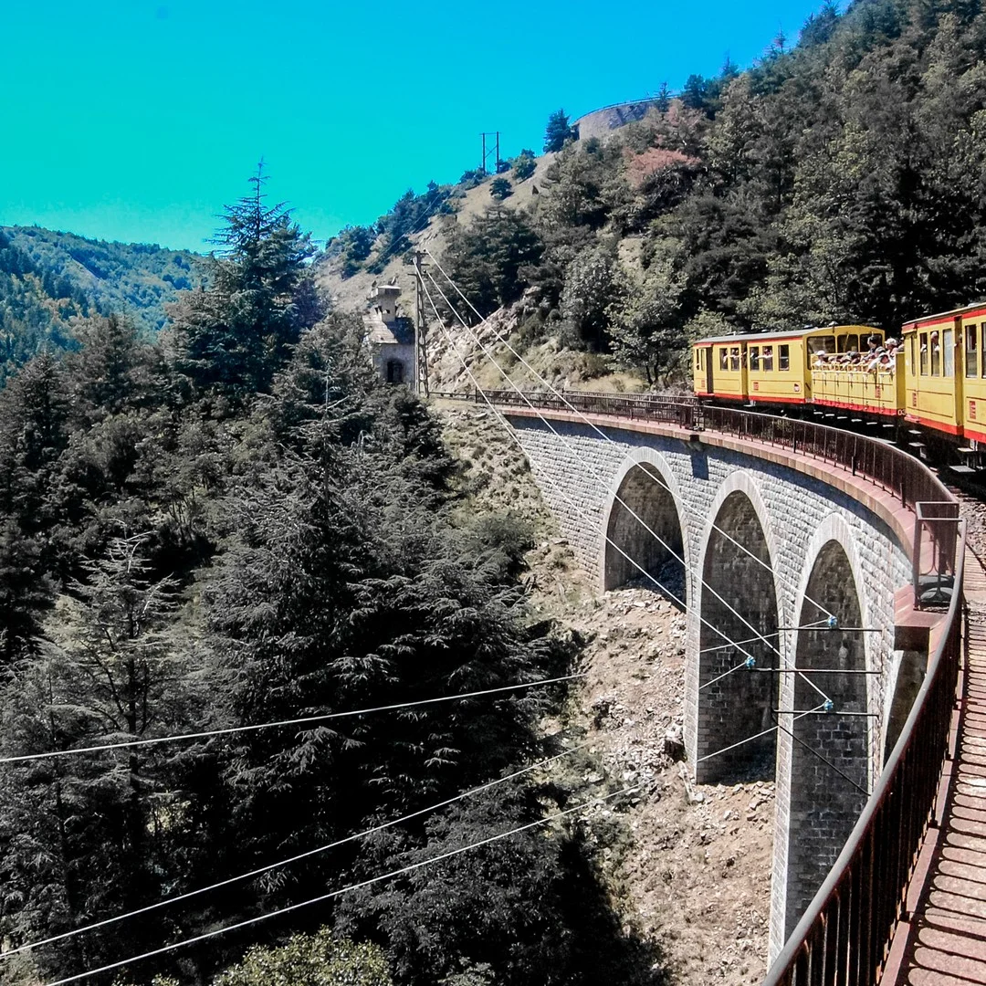 Photo 1 from Benjamin Simier’s Instagram post: Yellow train on a bridge front the mountain in the Pyrenees in France 🇫🇷