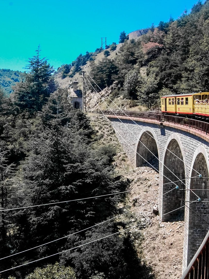 Photo 1 from Benjamin Simier’s Instagram post: Yellow train on a bridge front the mountain in the Pyrenees in France 🇫🇷