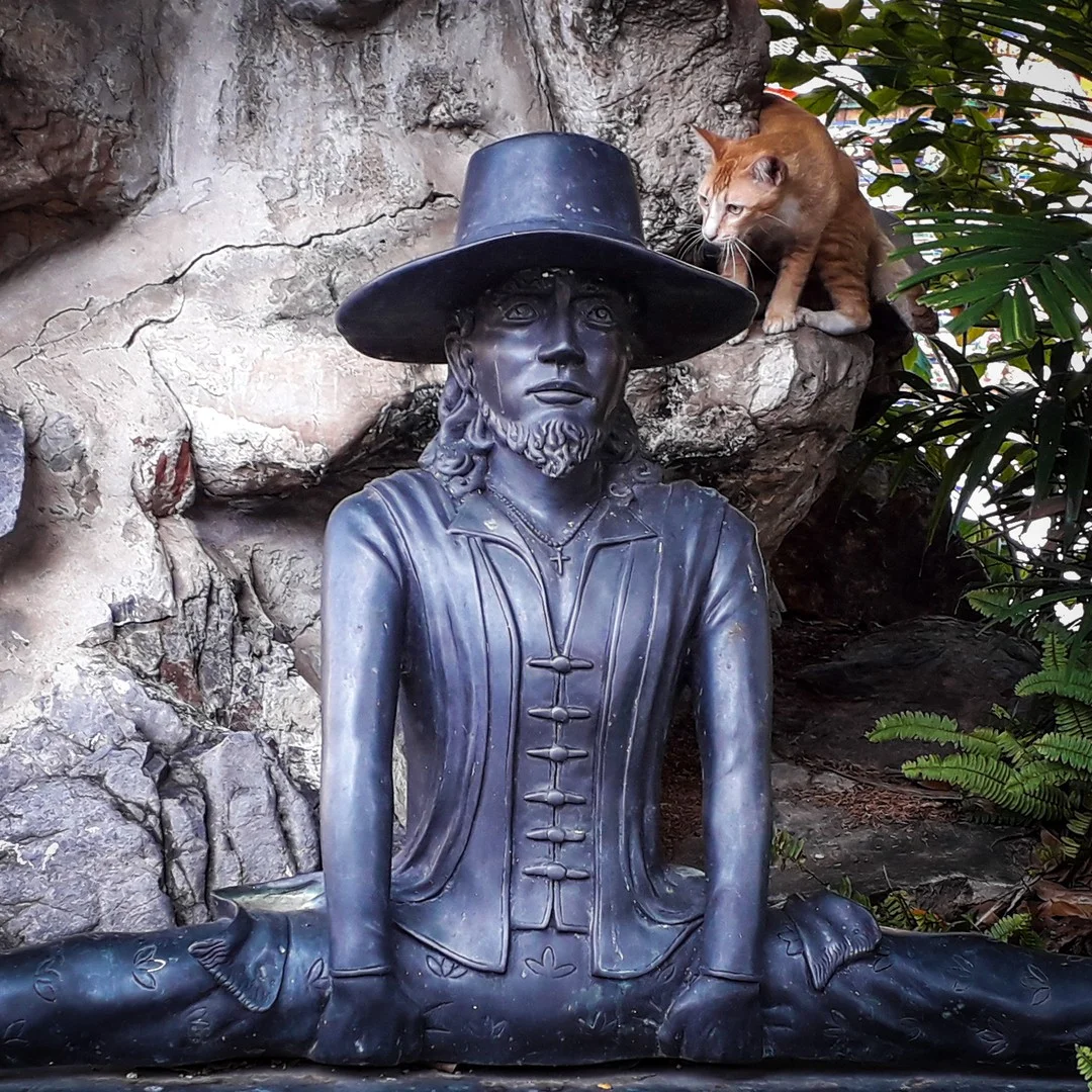 Photo 1 from Benjamin Simier’s Instagram post: Statue and cat in the foliage at Wat Pho in Bangkok in Thailand 🇹🇭🇹🇭