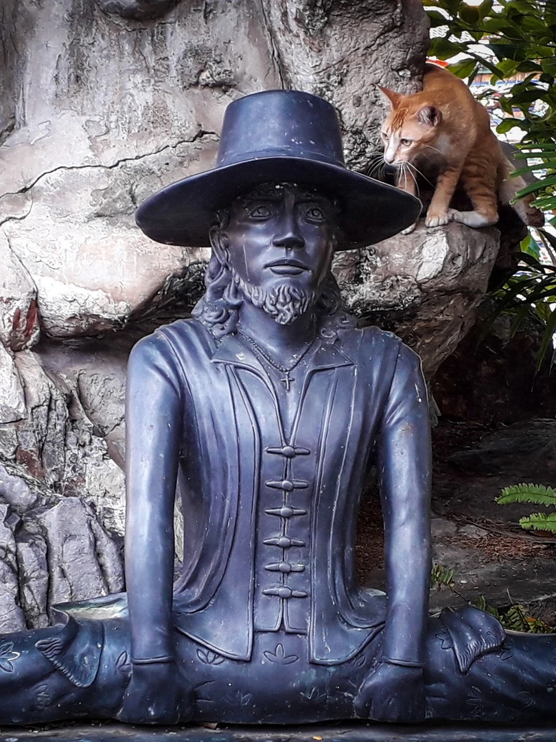 Photo 1 from Benjamin Simier’s Instagram post: Statue and cat in the foliage at Wat Pho in Bangkok in Thailand 🇹🇭🇹🇭
