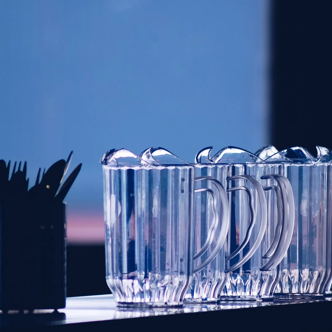 Photo 1 from Benjamin Simier’s Instagram post: Morning ? Or evening ? We can see water pitchers aligned on a table front the window.