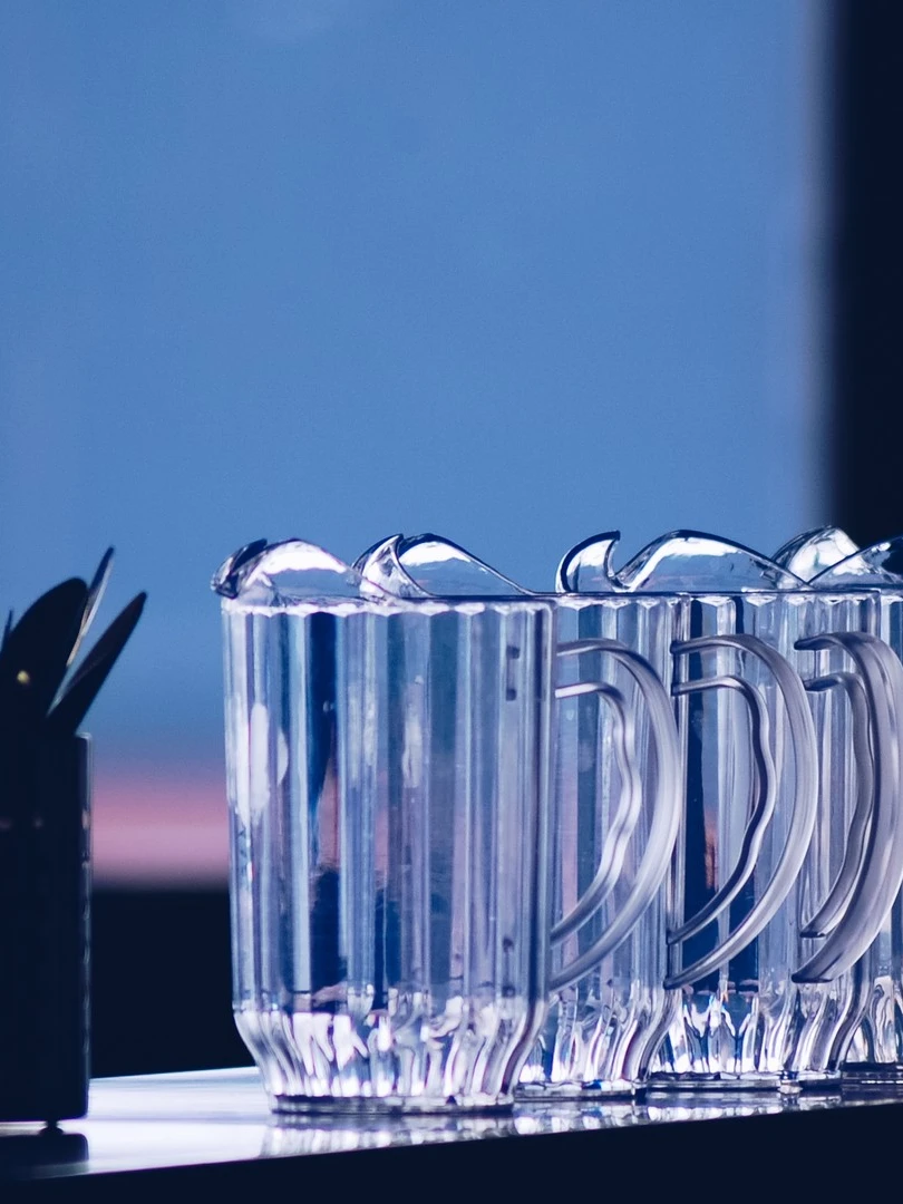 Photo 1 from Benjamin Simier’s Instagram post: Morning ? Or evening ? We can see water pitchers aligned on a table front the window.