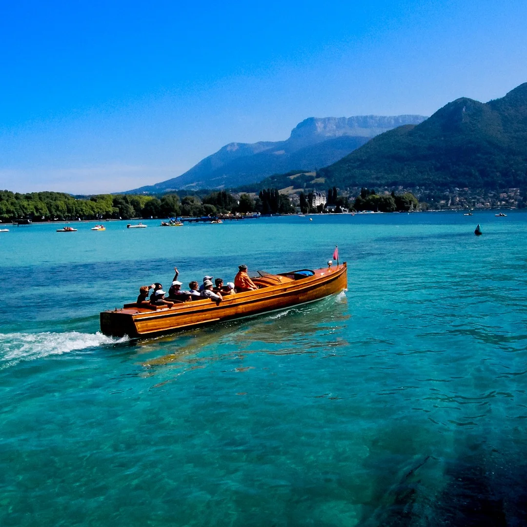 Photo 1 from Benjamin Simier’s Instagram post: Wooden boat facing the mountains on the Annecy lake in France 🇫🇷